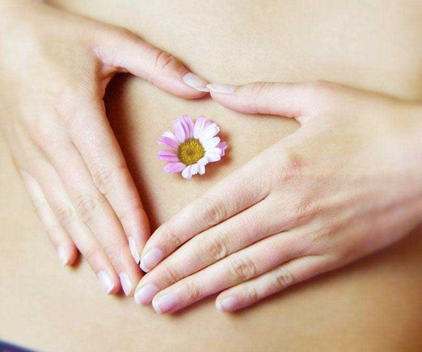 Hands around a flower on the belly